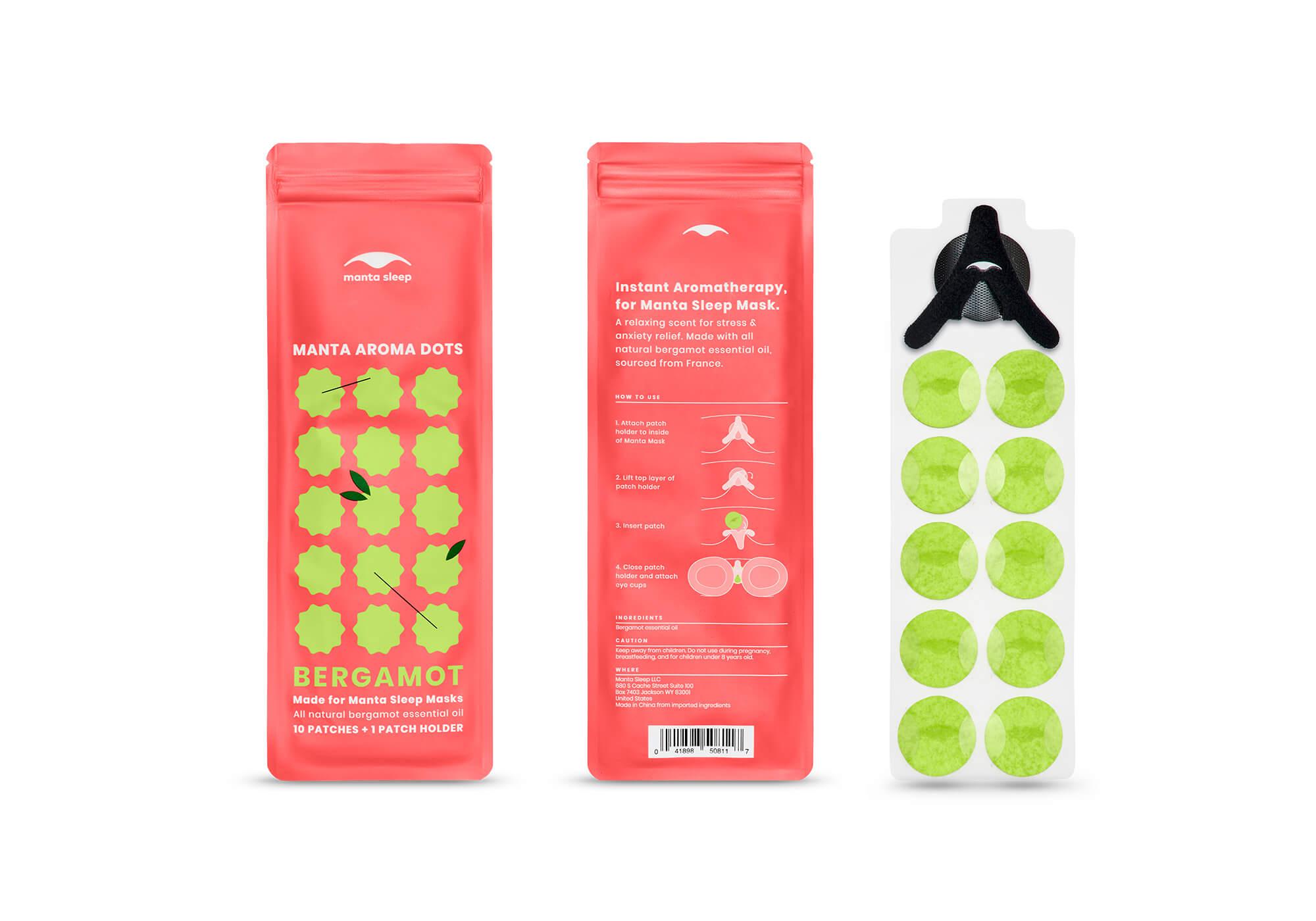 The front and back of a coral Bergamot Manta Aroma Dots packet displayed alongside a clear sheet containing 10 lime green patches and a black holder, on white.