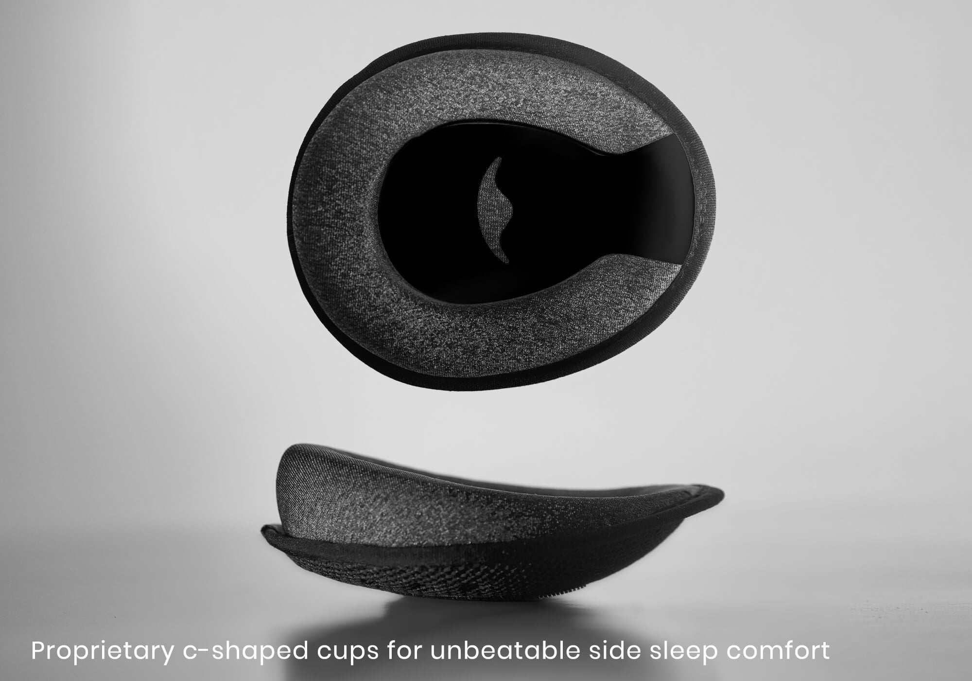 Studio shot of a black C-shaped eye cup from two angles, with caption "Proprietary C-shaped cups for unbeatable side sleep comfort".