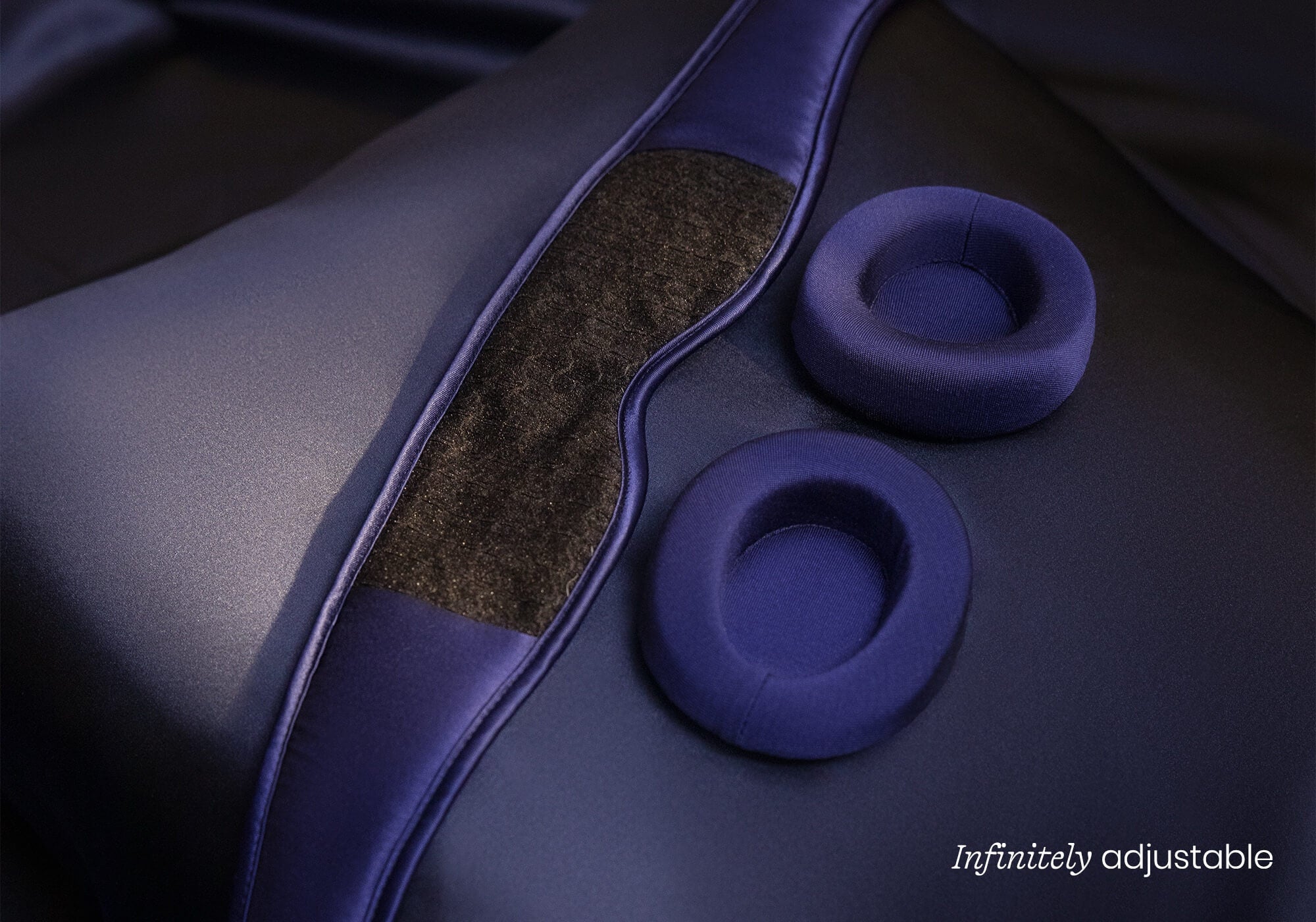 Interior view of a purple silk mask showing a large fuzzy patch for hook-and-loop fastening, captioned "Infinitely adjustable".