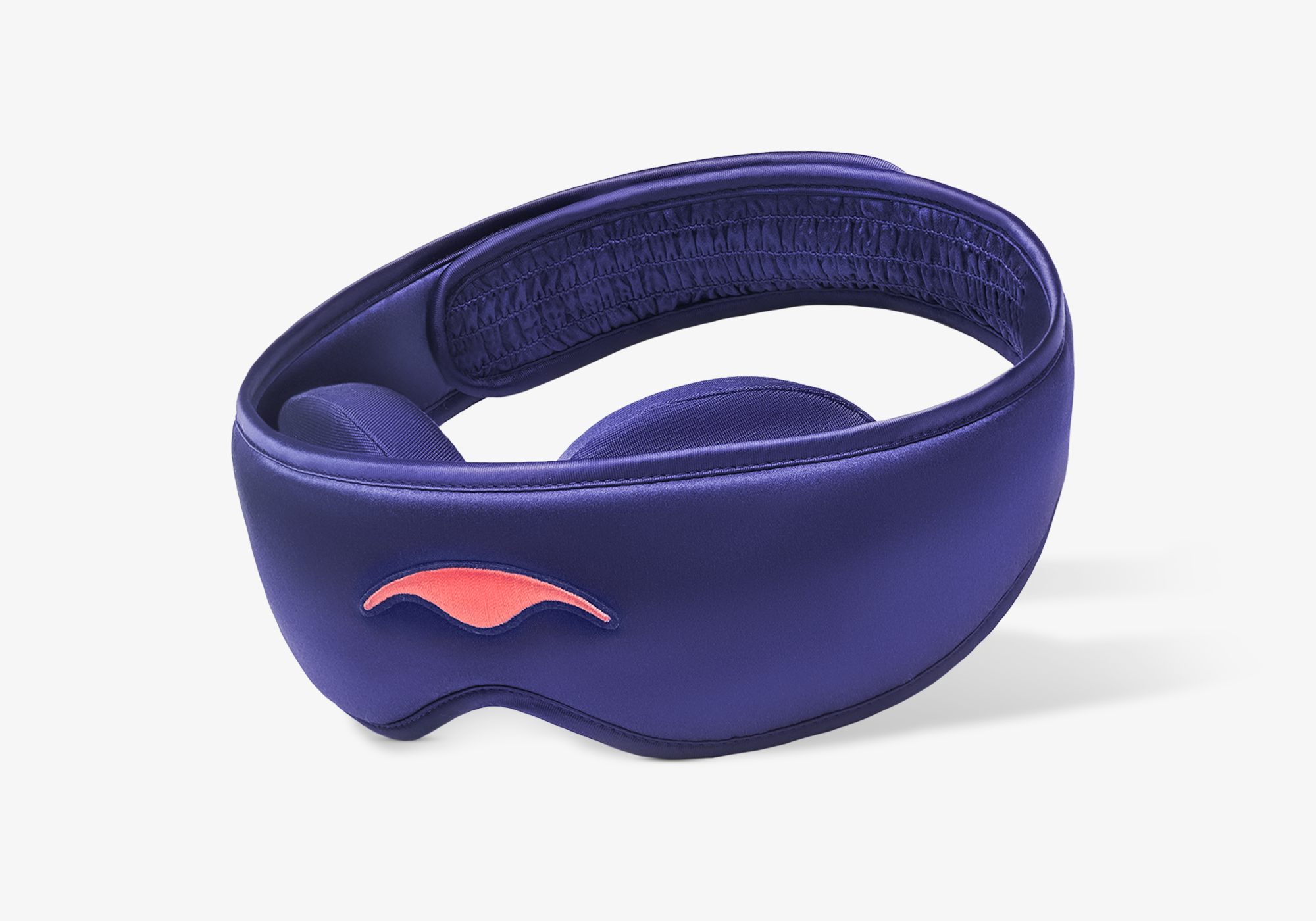 Three-quarter studio shot of the Manta SILK Sleep Mask in lustrous purple, featuring an embroidered coral logo and a ruched back strap section.