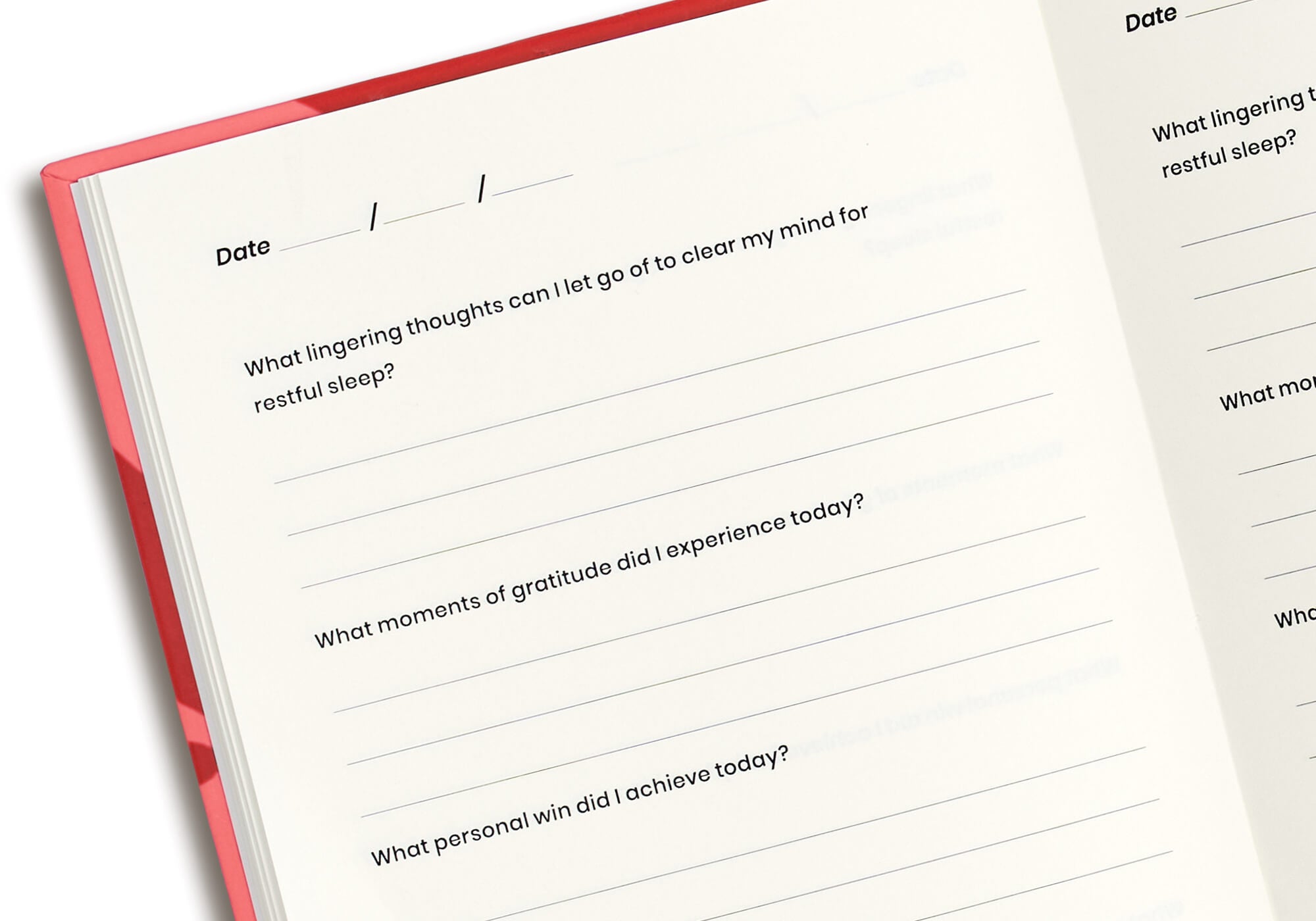 Top-angle close-up view of an open notebook page with structured prompt questions and date entry fields.