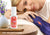 A person resting on a pillow holding a purple Manta SILK Sleep Mask in a hand, with white Manta Pillow Spray on the nightstand in the foreground. Text overlay: Deep, restorative sleep.