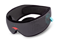 An angled view of the grey Manta SOUND Sleep Mask with built-in headphones, featuring a mesh texture, a coral logo, and electronic control icons on white.