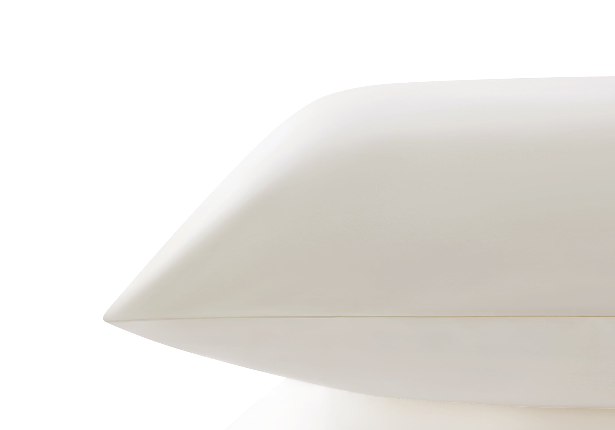 Side profile close-up showing the smooth edge and sleek texture of a pearl white Manta Sleep silk pillowcase.