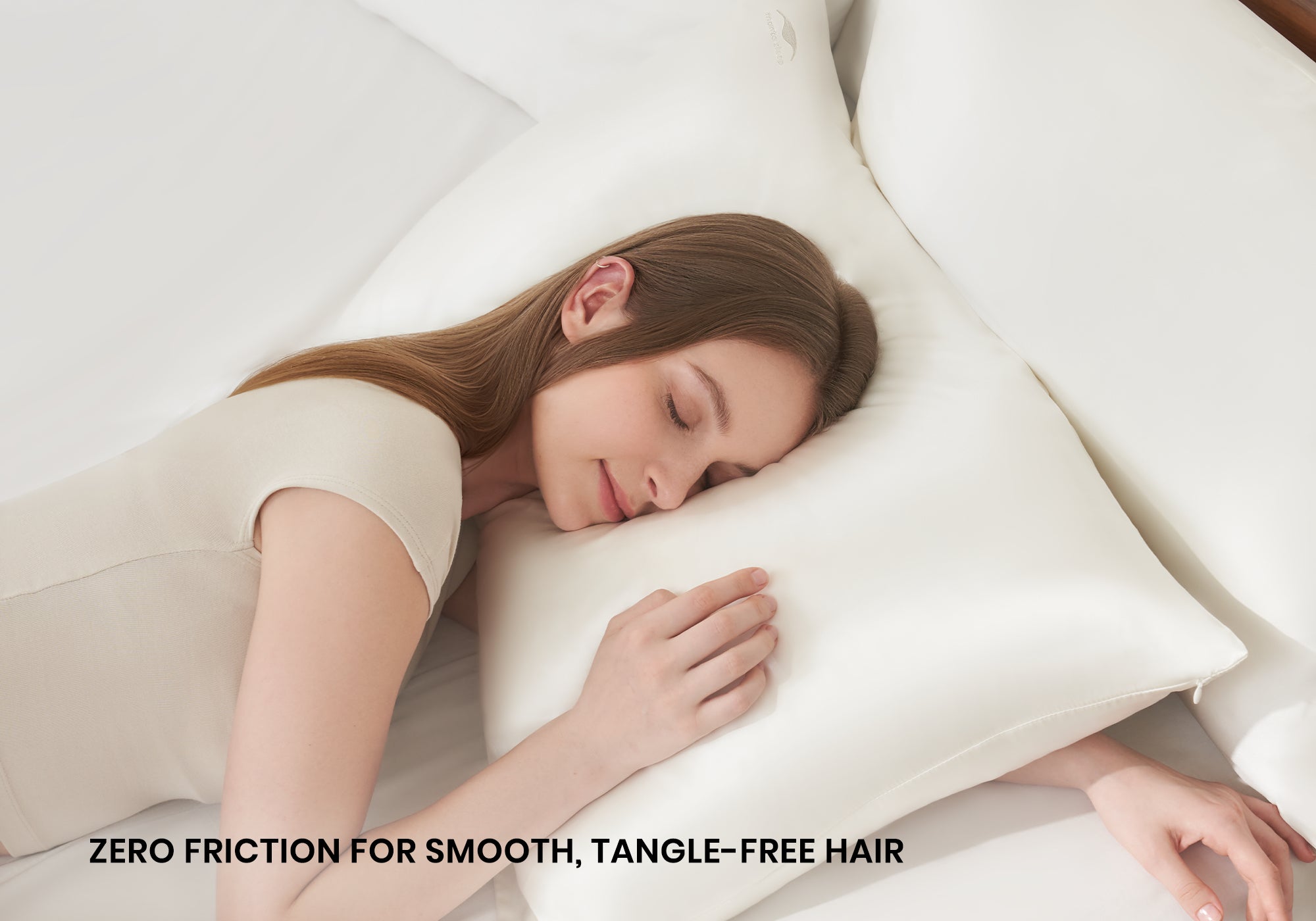 Overhead shot of a woman sleeping peacefully on a pearl white Manta Sleep silk pillowcase with text overlay "Zero friction for smooth, tangle-free hair".