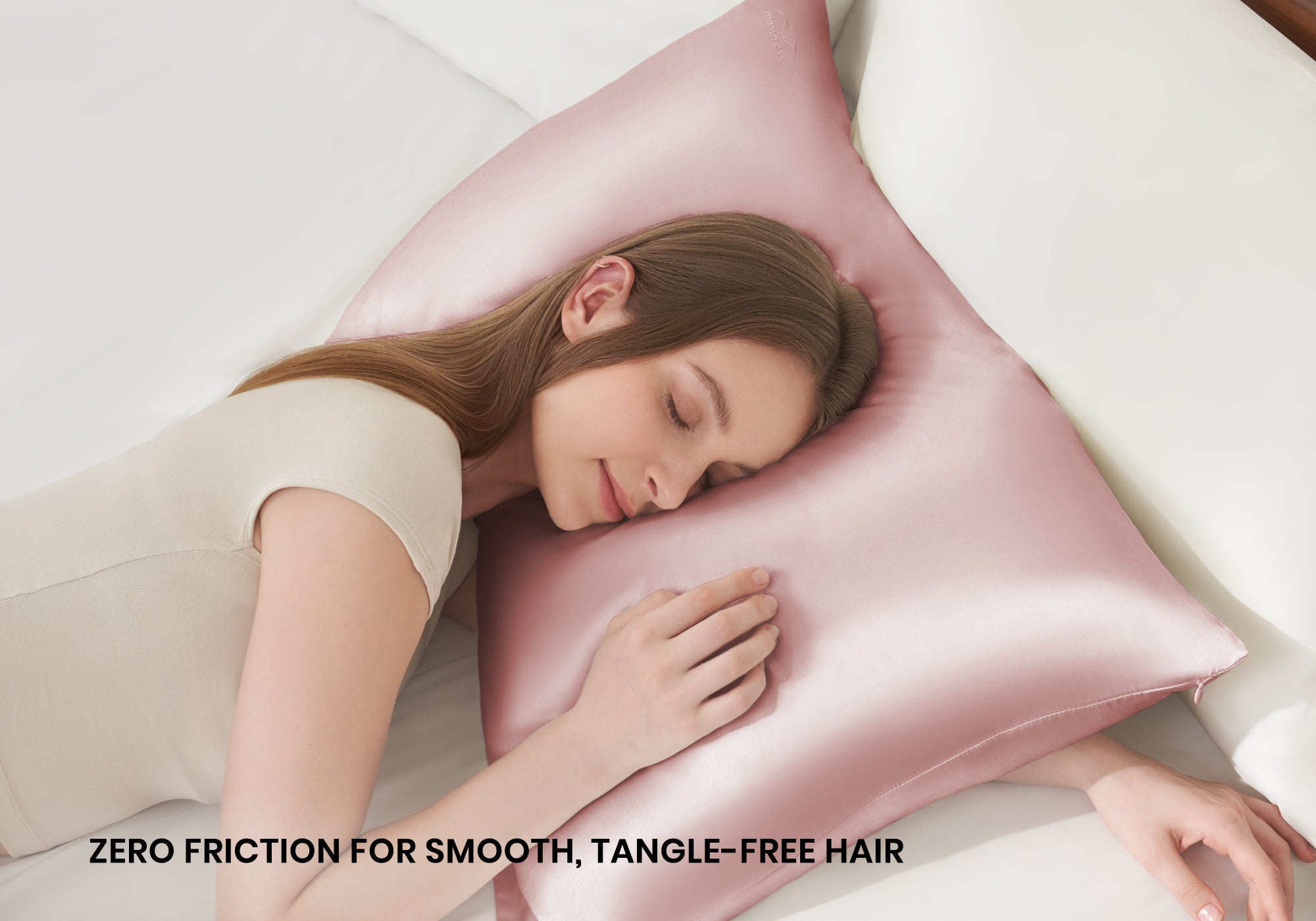 Overhead shot of a woman sleeping peacefully on a rose pink Manta Sleep silk pillowcase with text overlay "Zero friction for smooth, tangle-free hair".