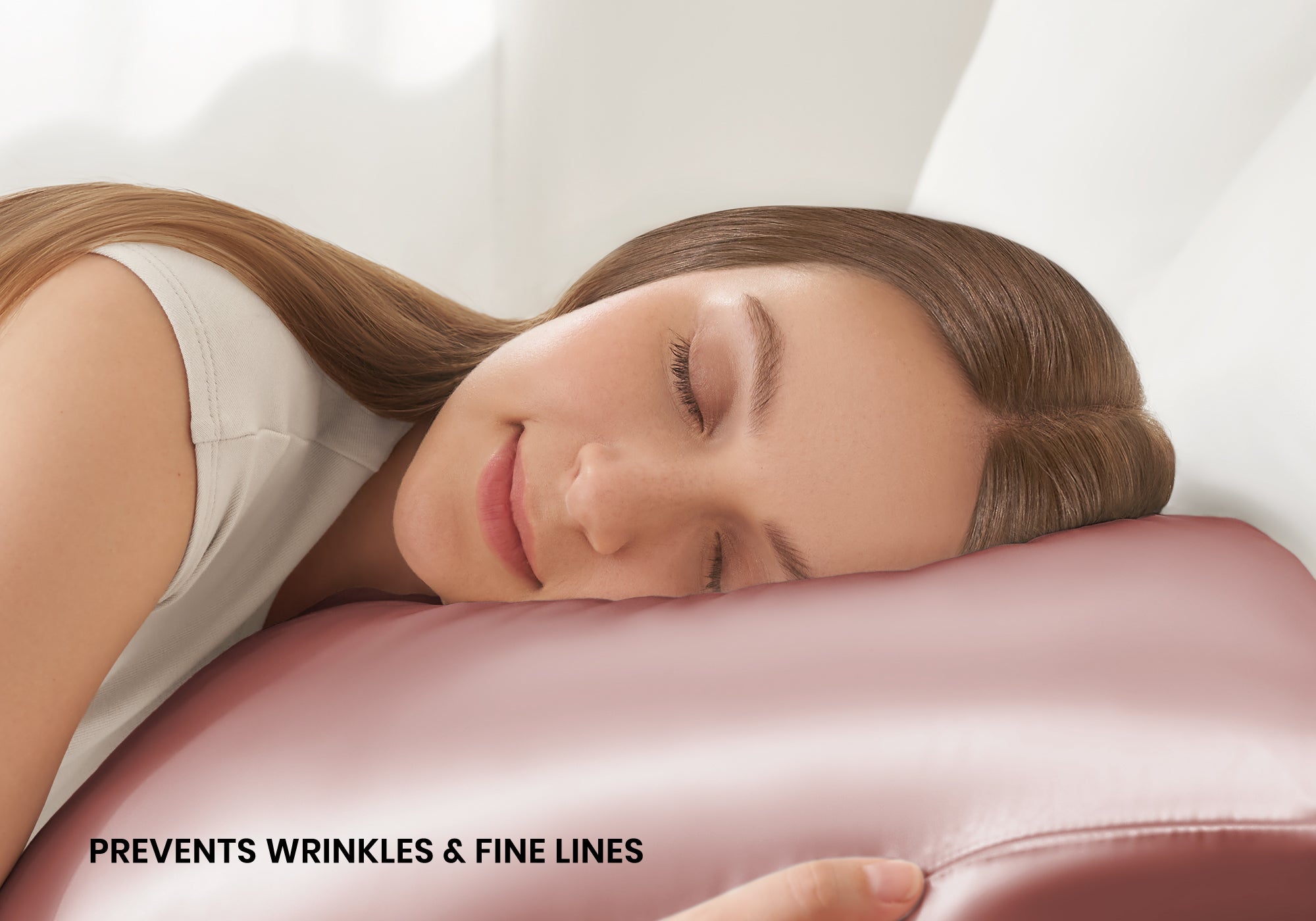 Close-up of a smiling woman sleeping on a rose pink Manta Sleep silk pillowcase with text overlay "Prevents wrinkles & fine lines".