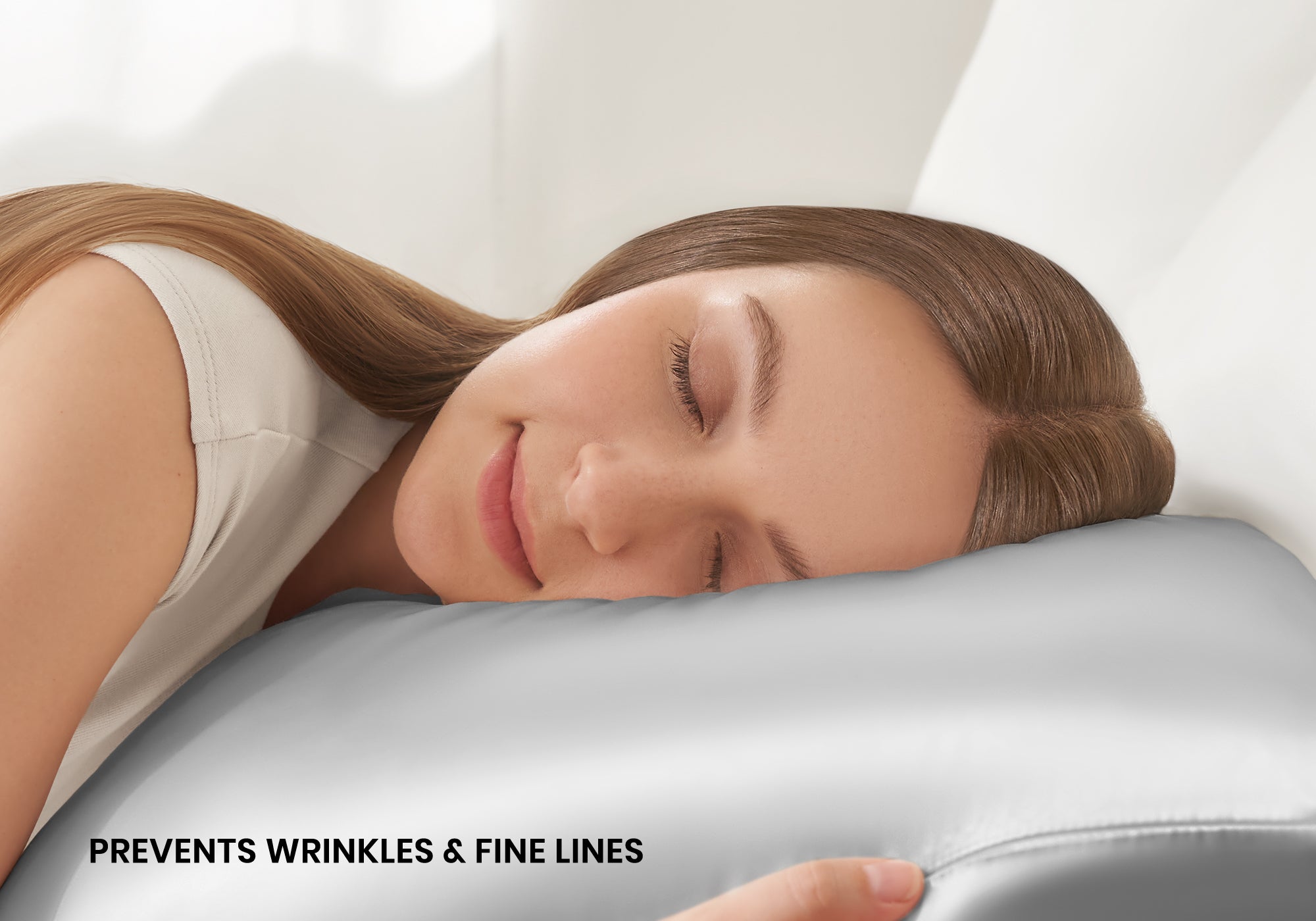 Close-up of a smiling woman sleeping on a crystal silver Manta Sleep silk pillowcase with text overlay "Prevents wrinkles & fine lines".