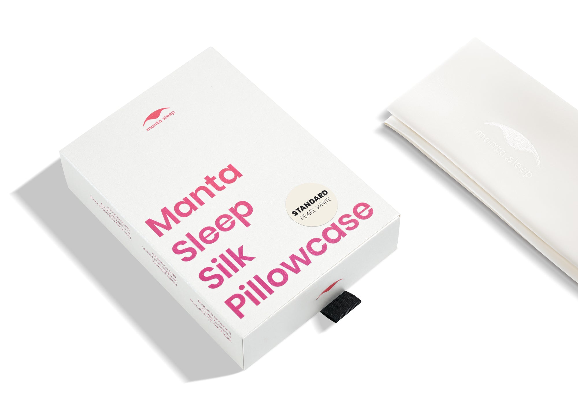 High-angle shot of the white product box with pink text and a folded pearl white Manta Sleep silk pillowcase.