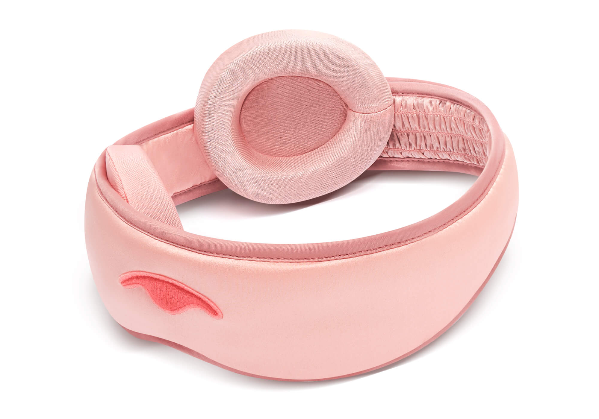 Angled view of a pink Manta SILK Sleep Mask with one eye cup detached and placed on top of the strap, showing the plush silk lining.