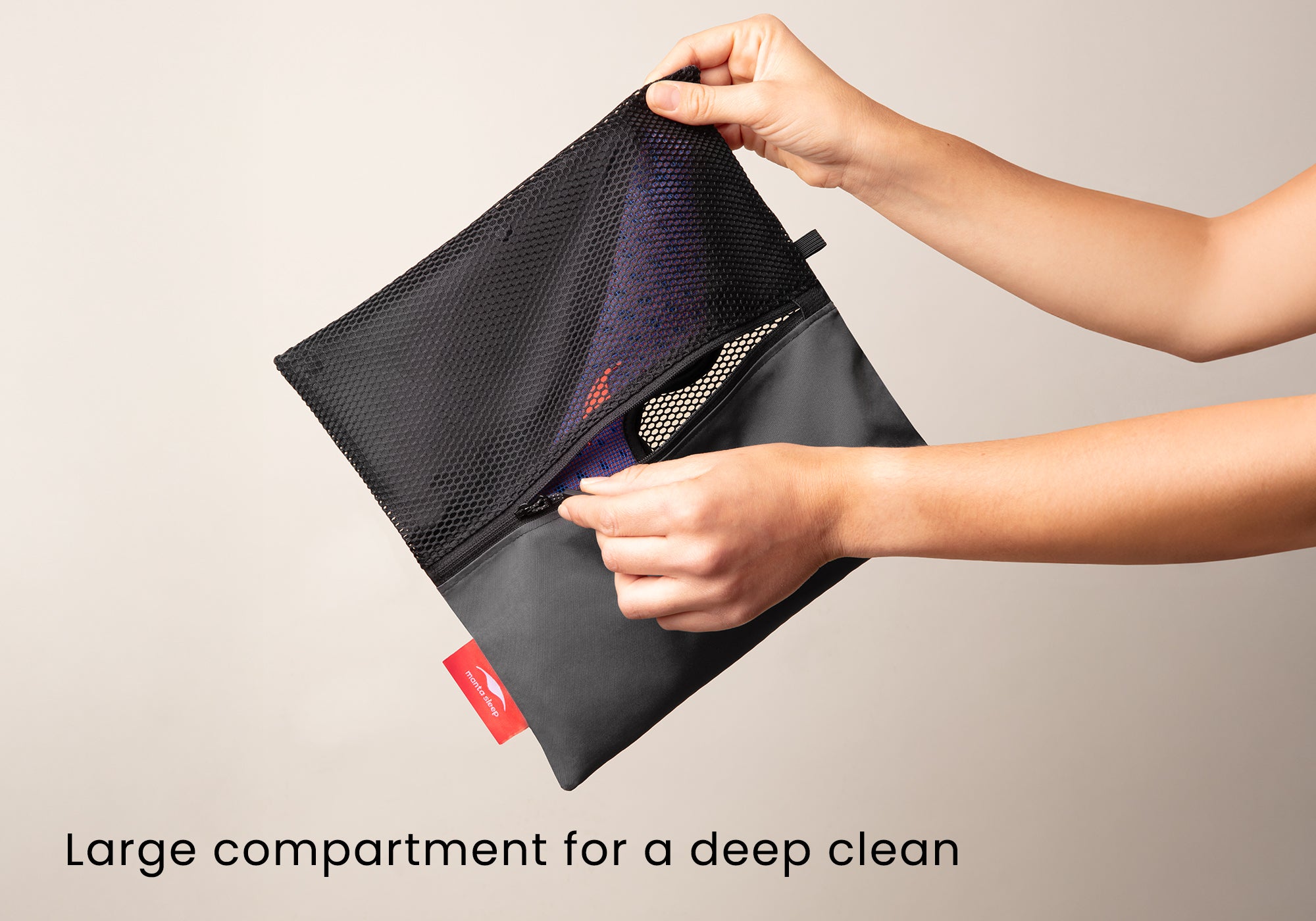 Hands holding the fully expanded laundry wash bag to show the large black mesh compartment designed for machine washing. Text overlay: "Large compartment for a deep clean".