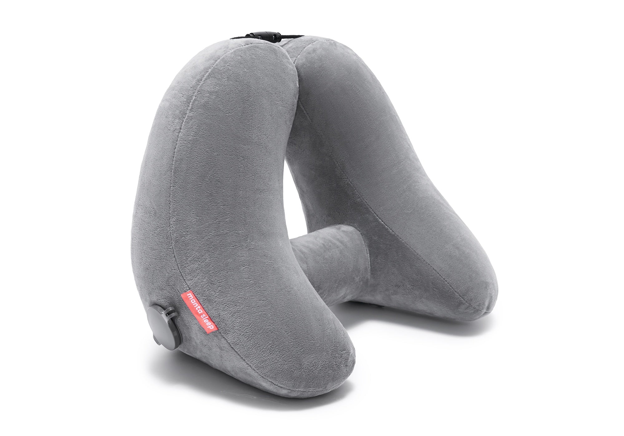 Studio shot of an inflated grey plush Manta Travel Pillow standing upright on a clean white background.
