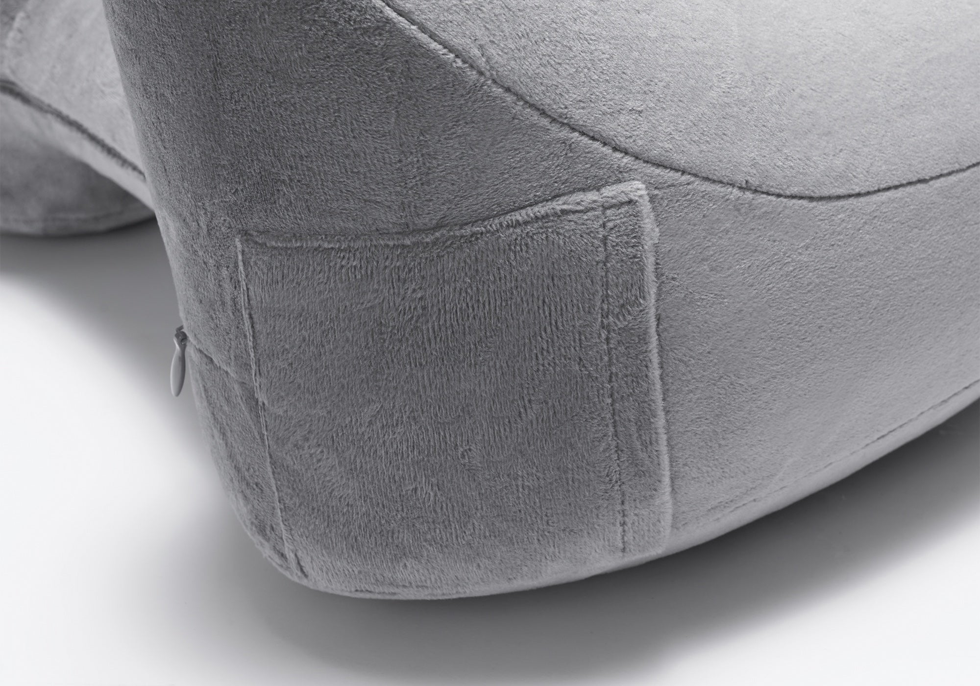 Close-up shot showing the soft fabric texture of a grey plush travel pillow.
