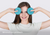 A smiling woman holding blue teal Manta COOL Eye Cups next to her eyes, with text: 'Minimal eye pressure'.