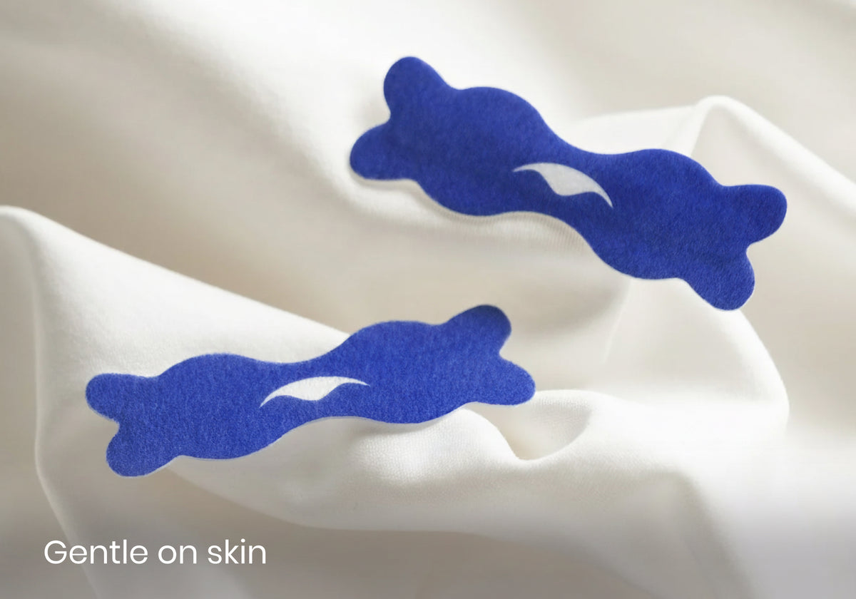 Two dark blue Manta nasal strips featuring the Manta Sleep logo resting on soft white fabric with overlay text reading "Gentle on skin".