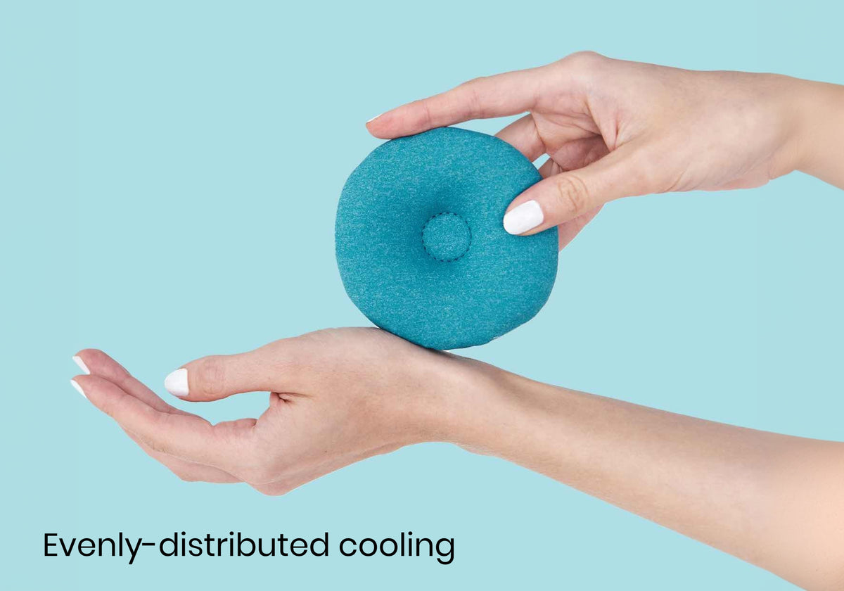 Close-up of hands holding a circular blue Manta COOL eye cup against light blue backdrop with text "Evenly-distributed cooling".