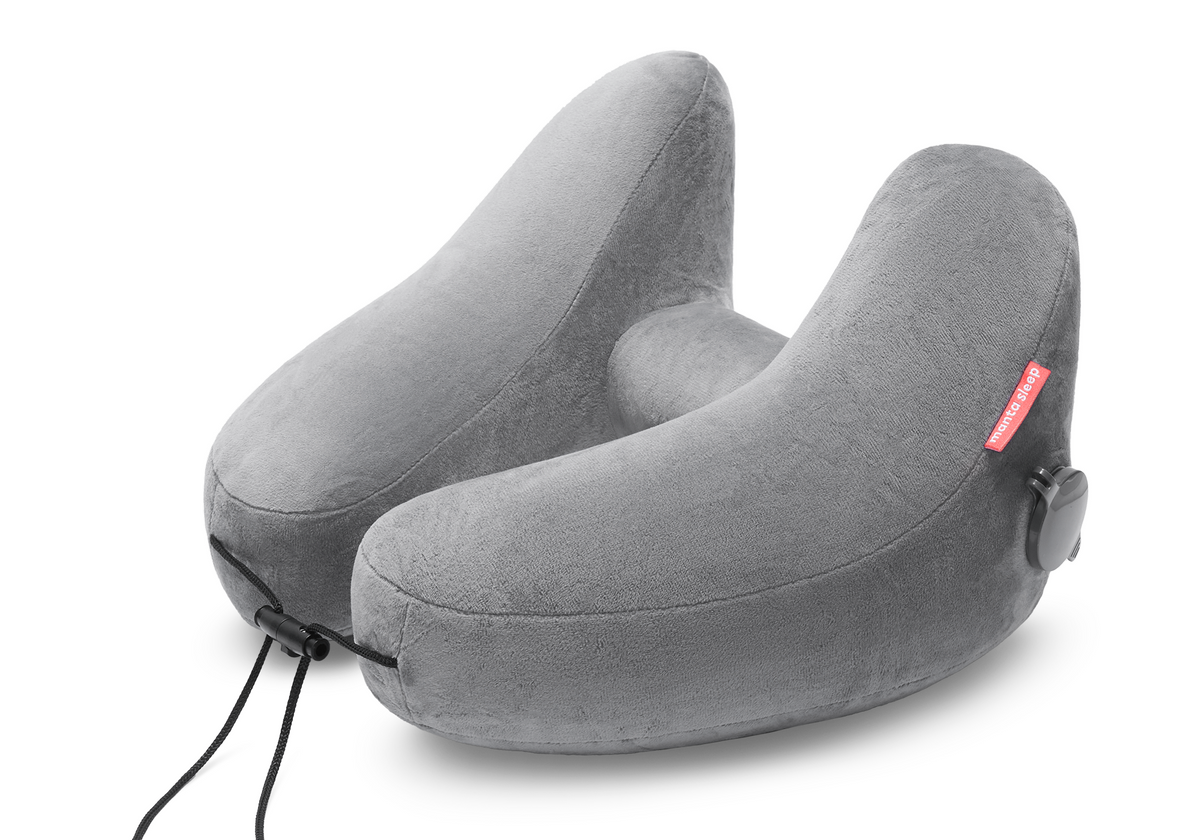 High-angle studio shot of an inflated grey plush Manta Travel Pillow with an adjustable front drawstring cord.