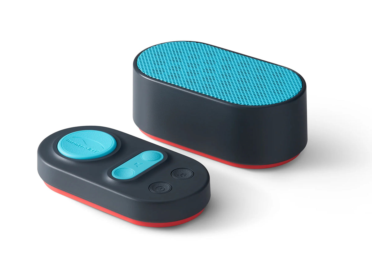 Black Manta Sleep White Noise Machine speaker with teal grill alongside its oval wireless remote control.