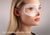 Side profile of a woman's face with a graphic highlighting a C-shaped eye cup over her eye. Text reads: Zero pressure on eyelids or lashes.