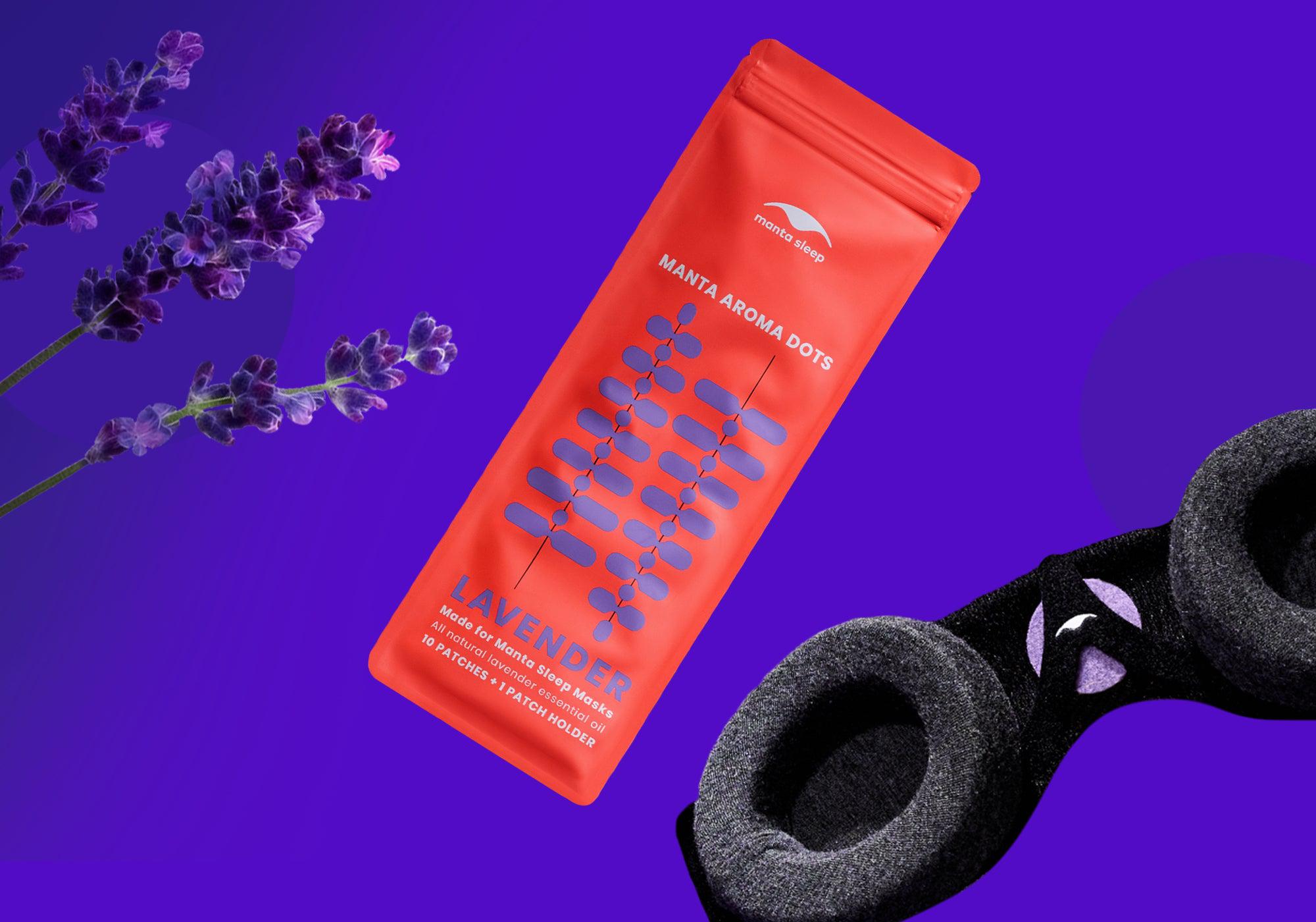 Lavender-scented Manta Aroma Dots packaging shown next to fresh lavender sprigs and a black sleep mask, on a vibrant purple background.