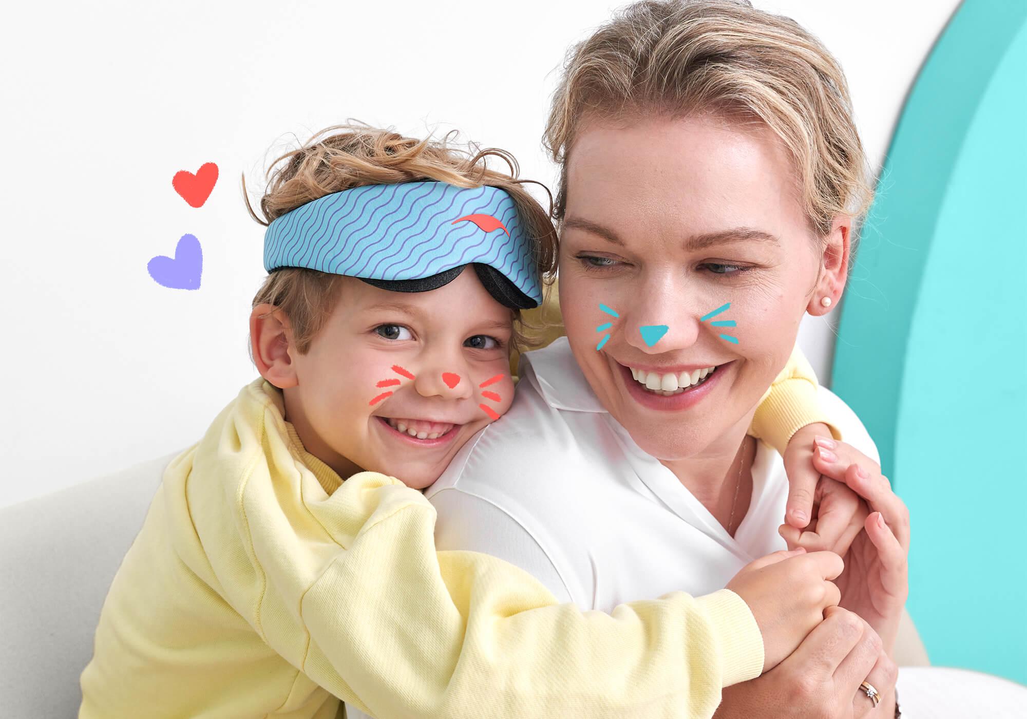 A cheerful scene showing a child giving an adult a piggyback hug from behind. The child wears a yellow sweatshirt and a light blue Manta KIDS Sleep Mask pushed up onto their forehead. Playful digital doodles, including animal whiskers and small hearts, are overlaid on their faces and background.