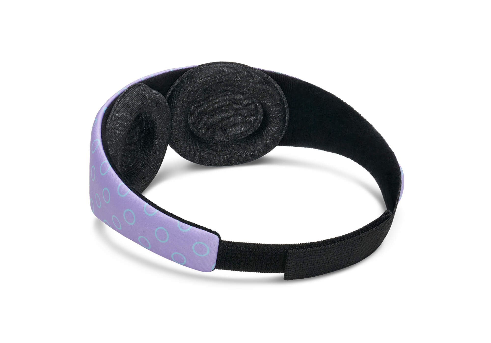 A rear-angle product shot showcasing the interior structure of the Manta KIDS Sleep Mask against a white background. The mask features a patterned purple outer band and two modular, adjustable eye cups lined in a soft black fabric. A solid black elasticized strap with a hook-and-loop closure section secures the back loop.
