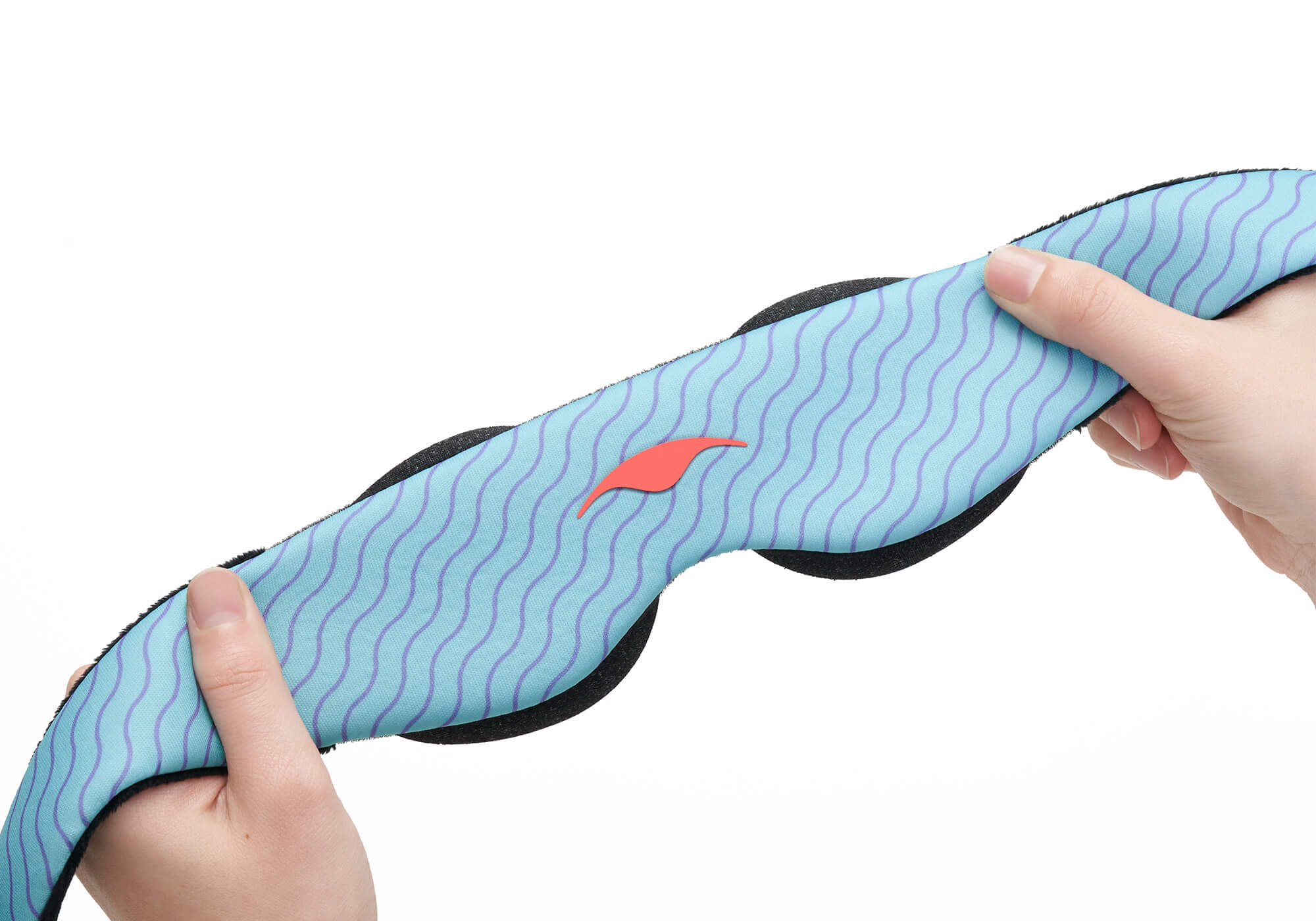 A close-up view of two hands stretching the flexible, elastic fabric band of a light blue Manta KIDS Sleep Mask against a clean white background. The mask features a pattern of purple wavy lines and a small orange Manta Sleep logo in the center.