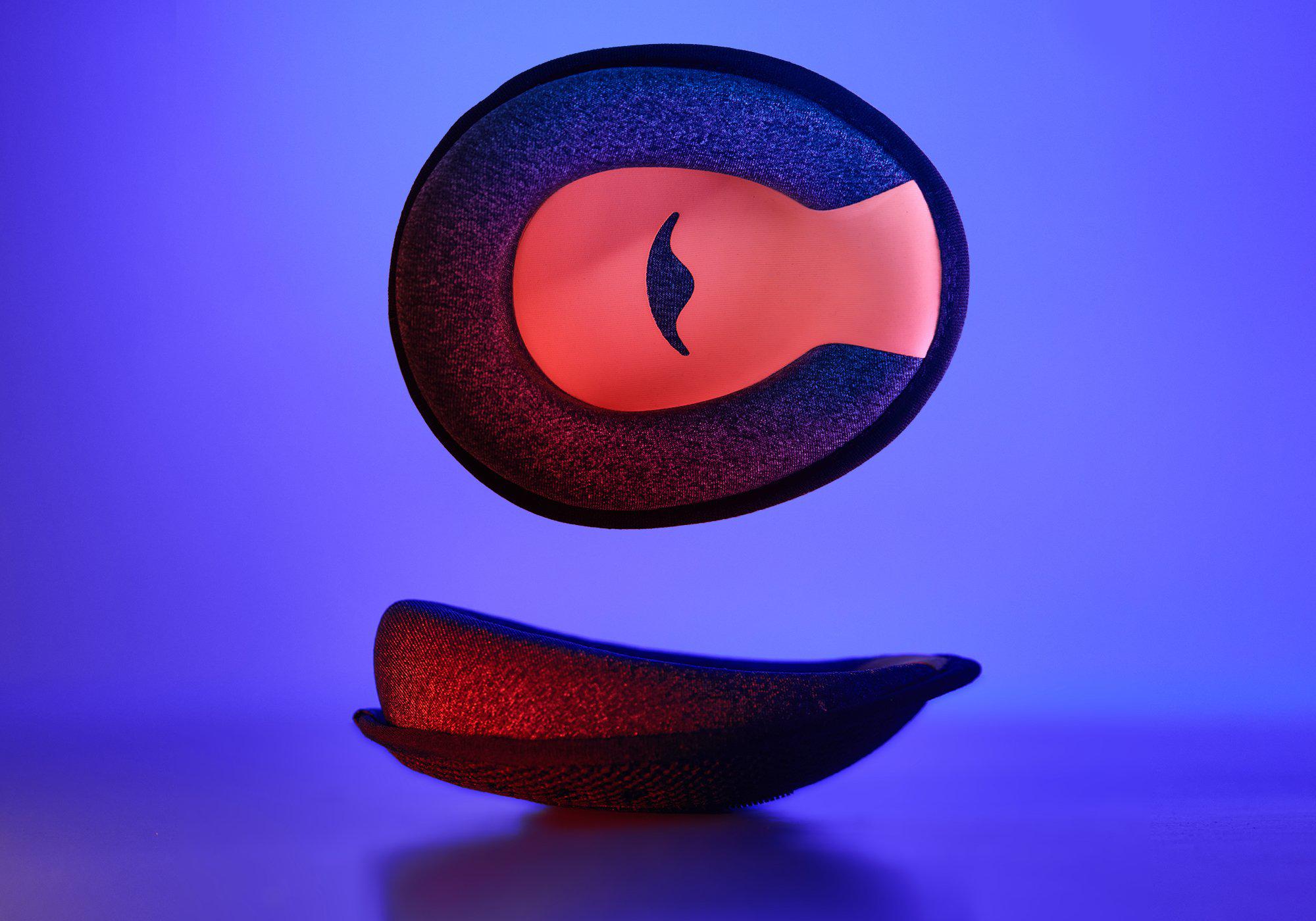 Studio shot showing a single C-shaped grey foam eye cup with a red interior, presented from both a front and a side profile view.