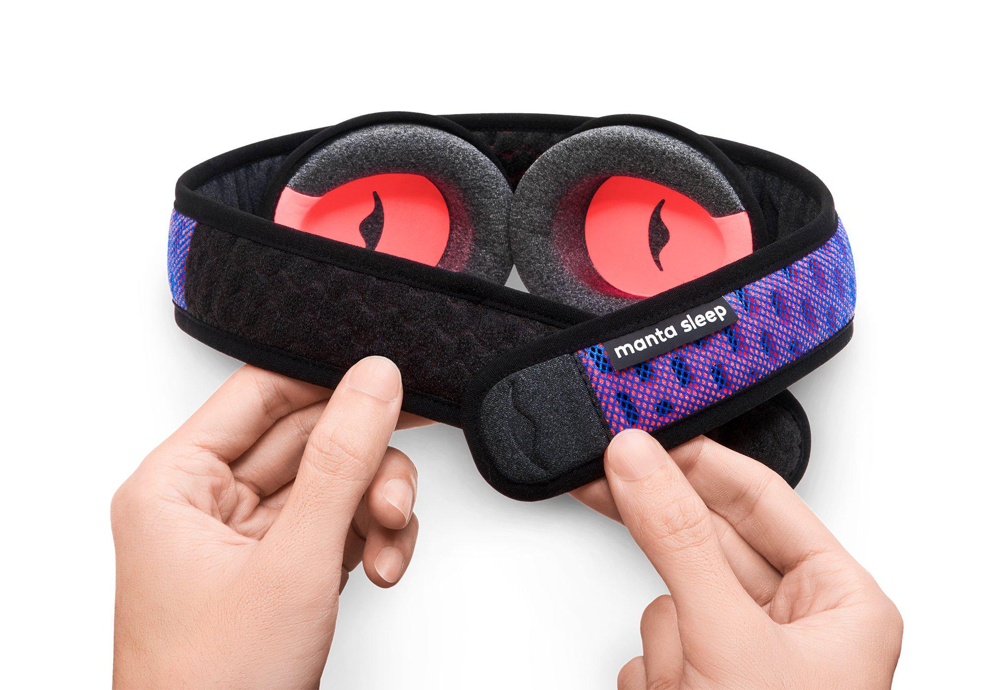 Two hands adjusting the adjustable hook-and-loop closure strap on a blue and purple mesh Manta PRO Sleep Mask against a white background.