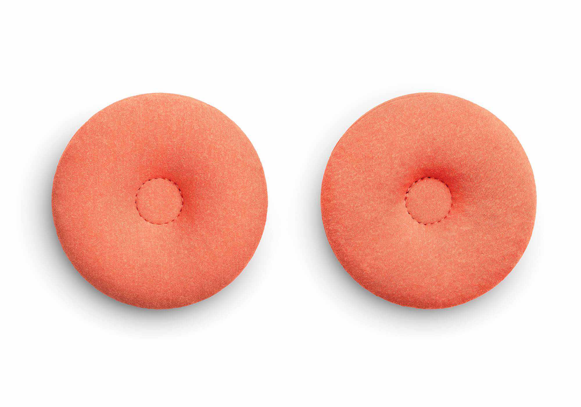 Top-down view of a pair of circular orange fabric eye cups with indented centers, isolated on a white background.