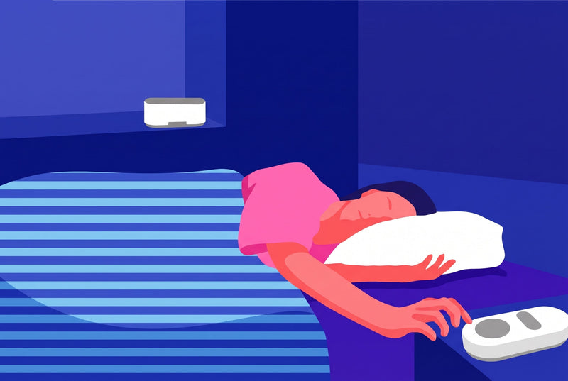 Woman sleeping soundly in bed beside a white noise machine on the nightstand, illustrating the best white noise for sleeping.
