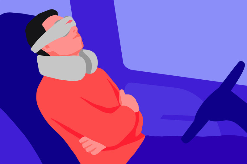 A man sleeping in the driver's seat, using the the best car sleeping accessories: a sleep mask and a neck pillow.