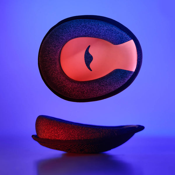 Studio shot showing a single C-shaped grey foam eye cup with a red interior, presented from both a front and a side profile view.
