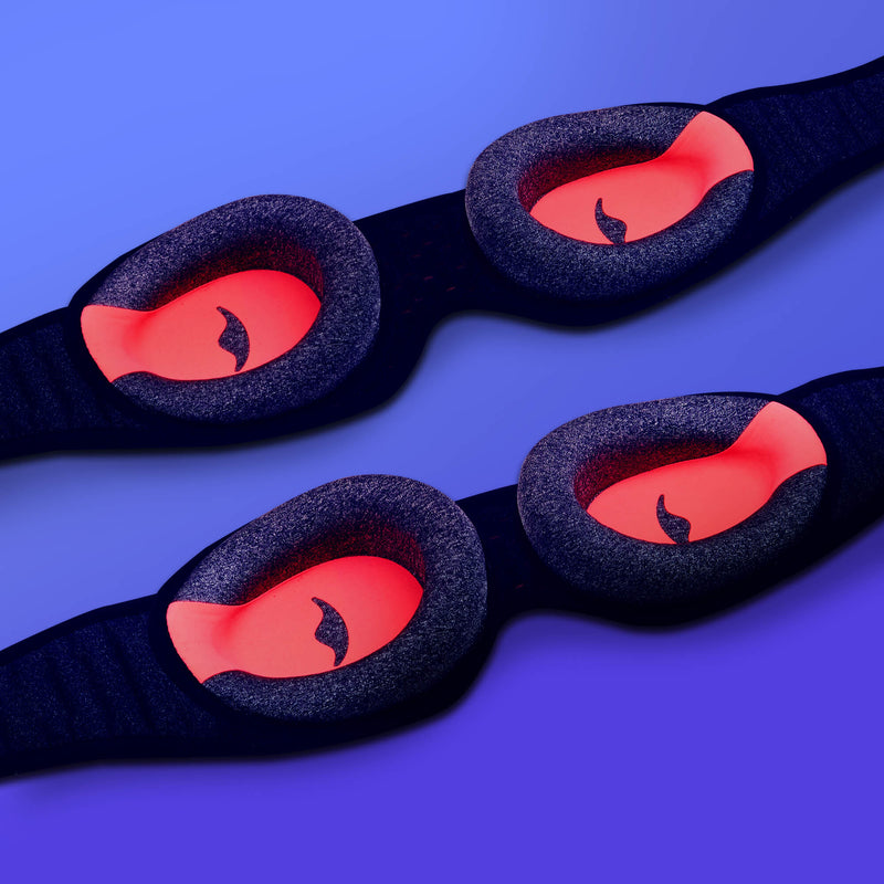 Two Manta Sleep Mask PROs arranged diagonally on a blue background, showing the inner grey foam eye cups with a red interior.