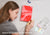 Overhead shot of a woman with closed eyes resting near a red Manta Sleep Journal, holding a pencil. Text overlay reads "Backed by science for better sleep".