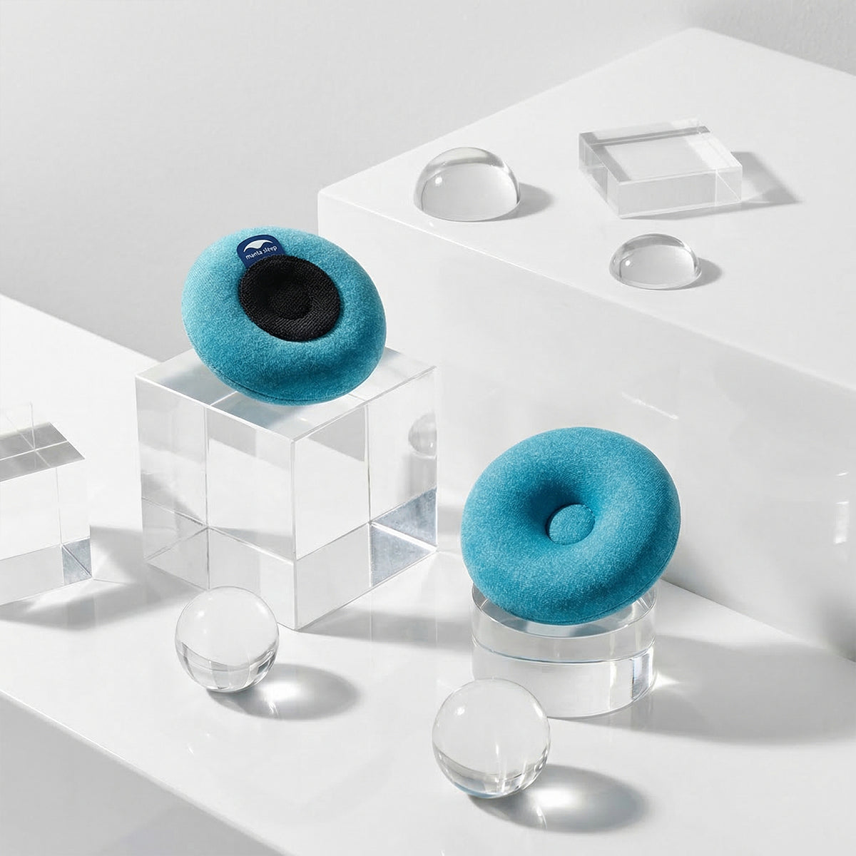 A pair of blue-teal Manta COOL Eye Cups on clear stands against a white background.