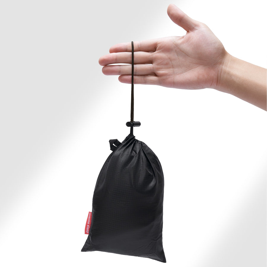 Eine Hand, die eine schwarze Tasche hält