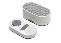Manta White Noise Machine in Stone White paired with its matching oval wireless remote control on a white background.
