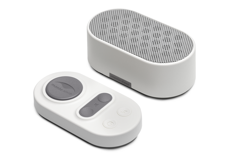 Manta White Noise Machine in Stone White paired with its matching oval wireless remote control on a white background.