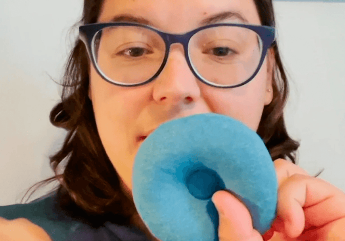Person holding blue teal Manta COOL Eye Cups in her hand in front of her face.