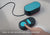 Hand pressing the teal button on a black Manta Sleep remote. Text: Easy-to-use remote with one-click start.