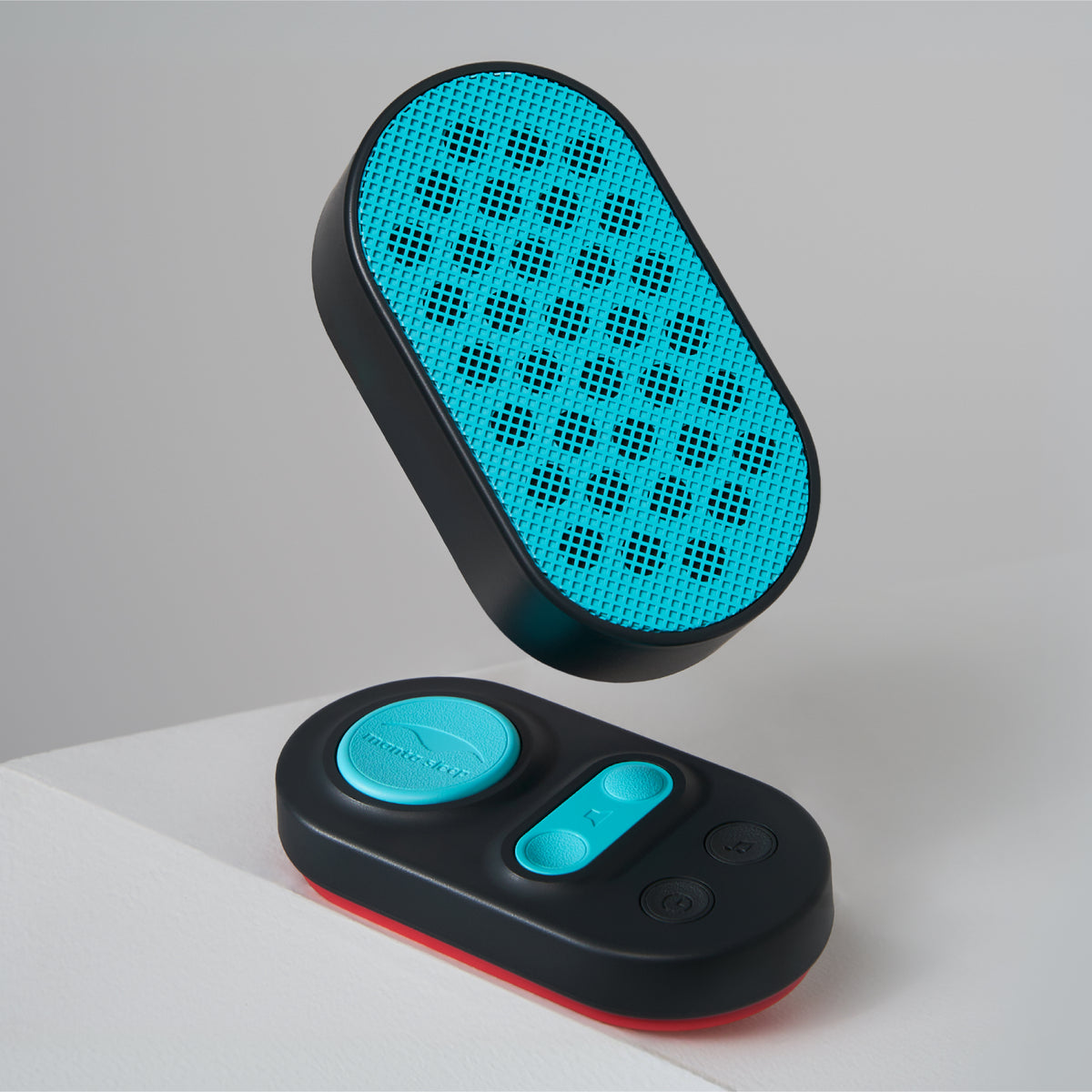 Manta Sleep White Noise Machine speaker floating above its matching black, teal, and red remote control.