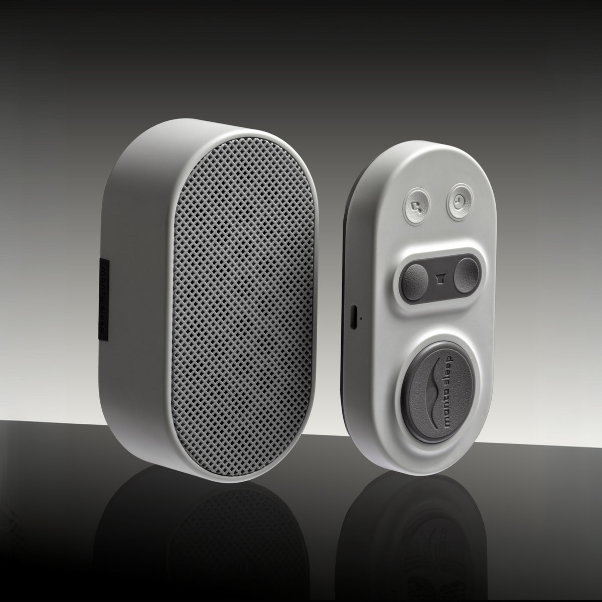 Stone White white noise machine speaker and matching oval remote on a reflective black surface.